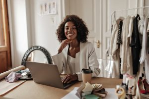 Mulher sorridente na frente de um notebook